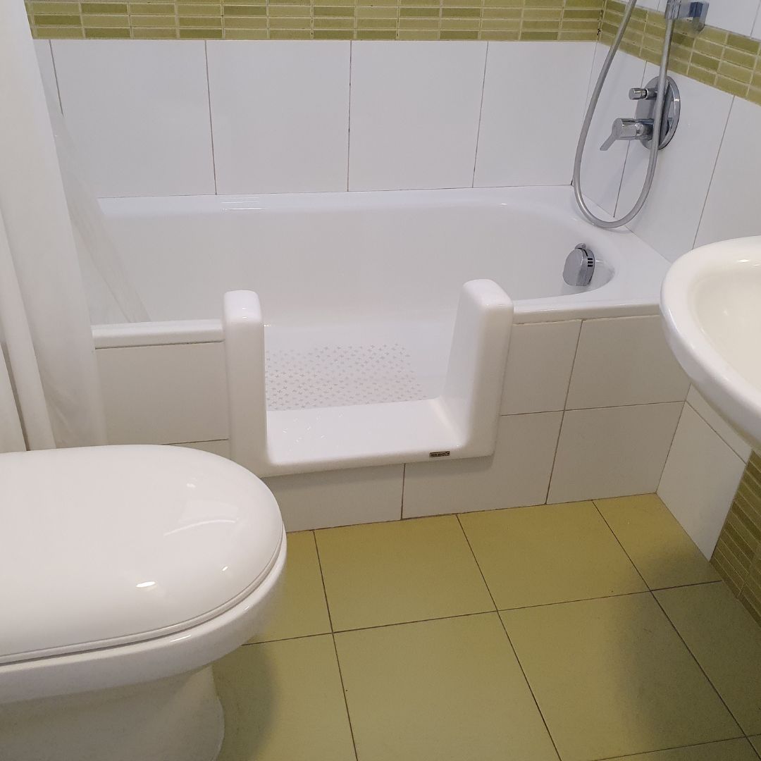 Persona mayor ingresando a una tina con rebaje instalado